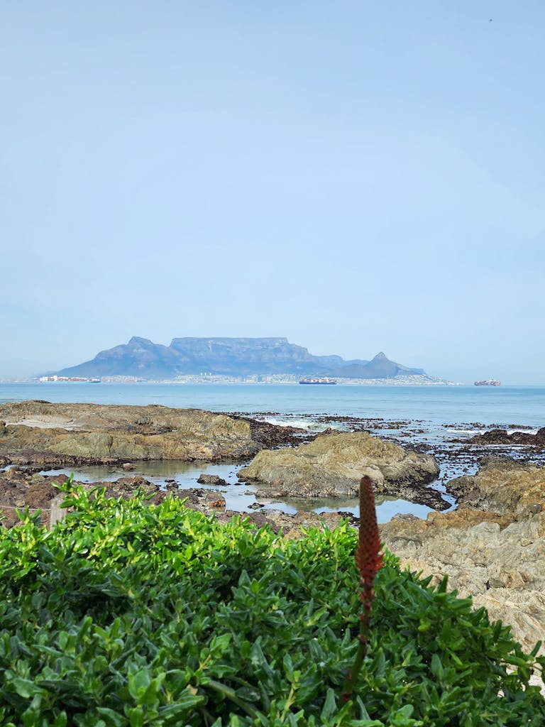 Serene coastal view of Table Mountain across the bay, captured in Cape Town, South Africa.